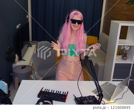 Beautiful young singer and musician broadcast from her home studio 121808695