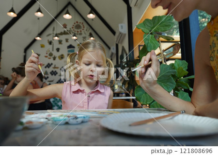 A young mother and her daughter enjoy a creative art session at home  121808696