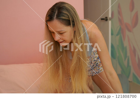 A young woman is enjoying a wonderfully serene morning in her bedroomnd  121808700
