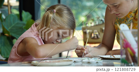 A young mother and her daughter enjoy a creative art session at home  121808729
