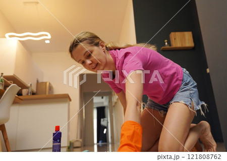 A woman is cleaning her living room at home 121808762