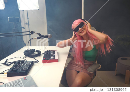 Beautiful young singer and musician broadcast from her home studio 121808965