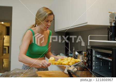 A young woman joyfully prepares a variety of healthy meals  121808967