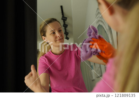 A woman is cleaning her living room at home A woman is cleaning her living room at home 121809135