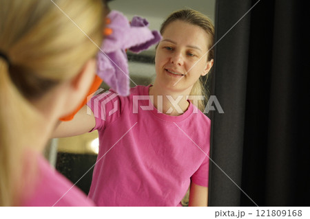 A woman is cleaning her living room at home 121809168