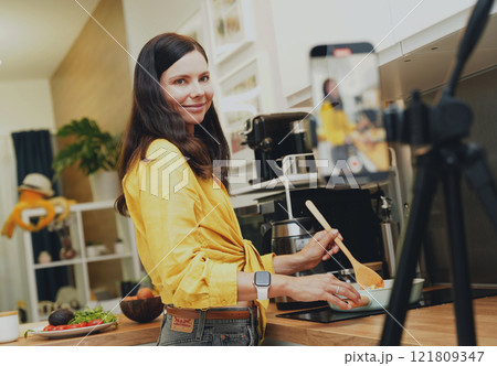 Young woman is broadcasting live from workshop how to prepare a vegetarian food 121809347