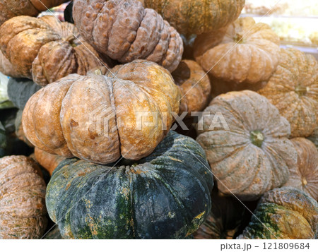 Various types of pumpkins are stacked on top of each other 121809684