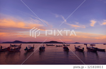 A beautifully serene view of a stunning sunset with fishing boats A beautifully serene view of a stunning sunset with fishing boats 121810011