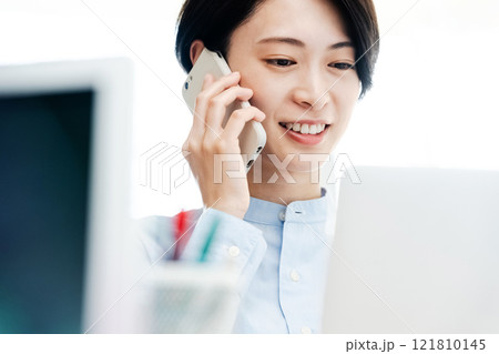 オフィスで通話するビジネスウーマン オフィスで通話するビジネスウーマン 121810145