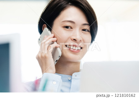 オフィスで通話するビジネスウーマン オフィスで通話するビジネスウーマン 121810162