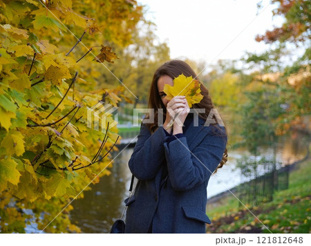 Girl, autumn image near yellow leaves in gray coat. Riga, Latvia Girl, autumn image near yellow leaves in gray coat. Riga, Latvia 121812648