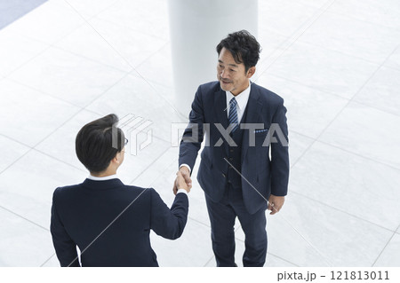 握手をする2人のビジネスマン 握手をする2人のビジネスマン 121813011