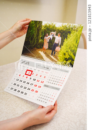 tear-off calendars with family photos in the hands 121813943