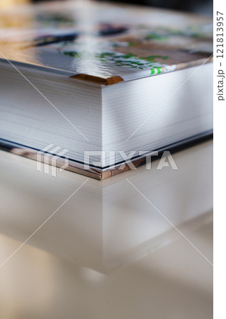 Corner of closed thick photo book with plastic pages and photo cover.  121813957