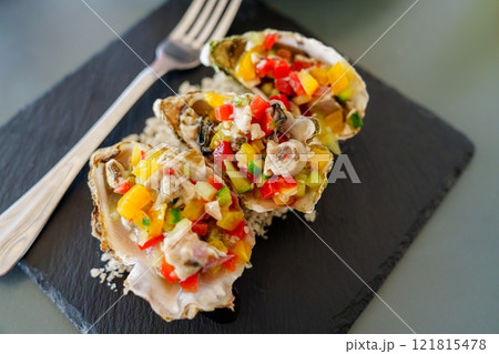 Oysters Rockefeller with diced vegetables served on the half shell Oysters Rockefeller with diced vegetables served on the half shell 121815478