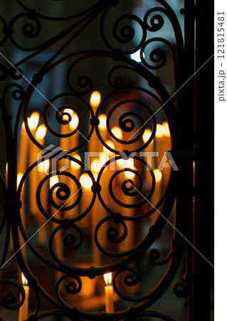 Exquisite ornate metal latticework with softly glowing candles beautifully arranged behind it 121815481