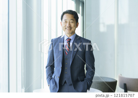 オフィスの窓際に立つミドルエイジの男性のポートレート　撮影協力：学校法人電波学園 東京電子專門学校 121815707