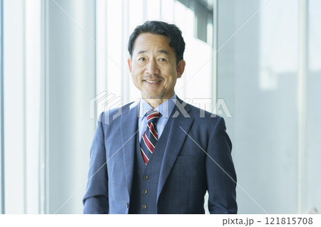 オフィスの窓際に立つミドルエイジの男性のポートレート　撮影協力：学校法人電波学園 東京電子專門学校 121815708