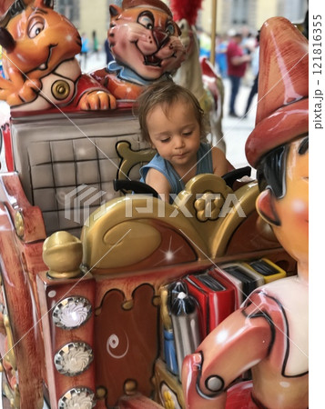 Little boy on a traditional city carousel Little boy on a traditional city carousel 121816355