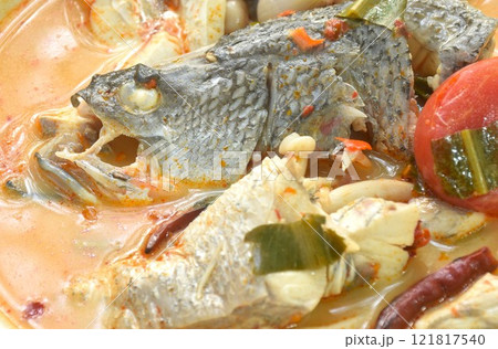 boiled bass fish head and mushroom in tom yum soup on plate boiled bass fish head and mushroom in tom yum soup on plate 121817540