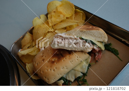 a girl or a guy throws delicious mexican nachos with cheese into a glass plate, chips fly 121818702