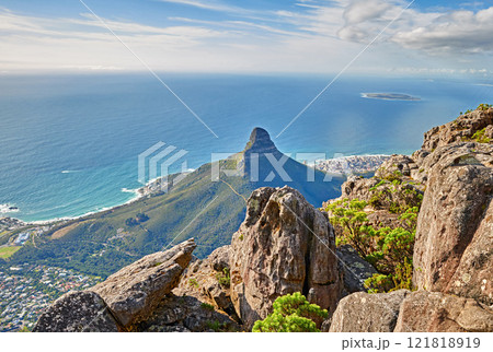 Aerial view of a calm ocean and a mountain with blue cloudy sky background and copy space. Beautiful nature landscape of the sea and horizon from Table Mountain tourism attraction in Cape Town Aerial view of a calm ocean and a mountain with blue cloudy sky background and copy space. Beautiful nature landscape of the sea and horizon from Table Mountain tourism attraction in Cape Town 121818919