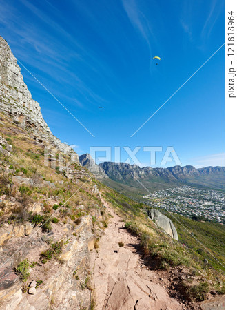 Paragliding from Lions Head with a beautiful view of Table Mountain in Cape Town, South Africa. Lush green trees growing in harmony on rocky terrain. Tourist attraction for adventurous explorers 121818964