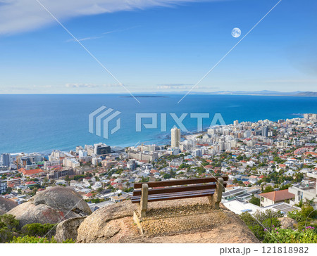 Scenic landscape banner view of a public bench on a cliff or hill overlooking the city and the ocean. Empty, peaceful, and quiet natural area with a seat for relaxation in nature with copyspace 121818982