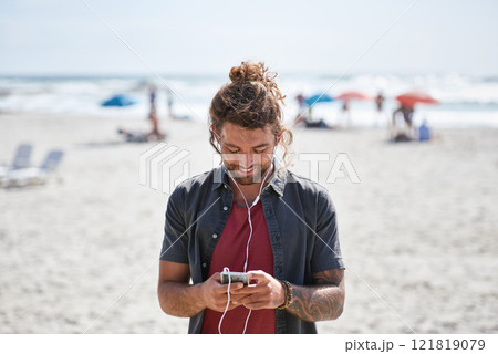 happy young man using smartphone on beach enjoying sunny day listening to music wearing earphones happy young man using smartphone on beach enjoying sunny day listening to music wearing earphones 121819079