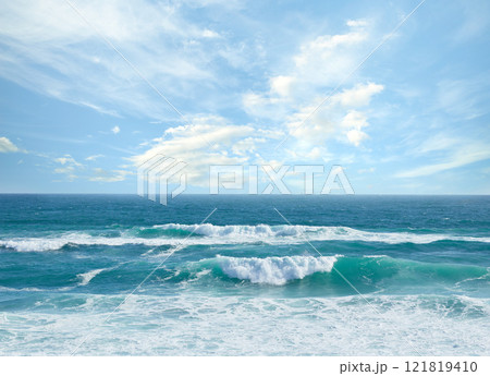 Landscape banner view of waves rolling onto the seashore against a cloudy blue sky in summer. Peaceful scenic view of clear beach water in a tropical area. Relaxing natural environment on the coast Landscape banner view of waves rolling onto the seashore against a cloudy blue sky in summer. Peaceful scenic view of clear beach water in a tropical area. Relaxing natural environment on the coast 121819410