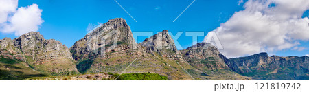 Mountain landscape against a cloudy blue sky background with copy space. Rocky hills and cliffs on The twelve apostles in Cape Town, Western Cape. Beautiful travel destination and tourist attraction 121819742