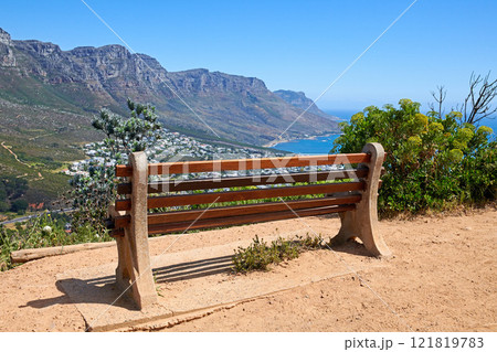 Relaxing resting place along a mountain trail, with beauty in nature and peaceful harmony. Empty bench on Table Mountain, Cape Town, South Africa with a beautiful view of Lions Head and copy space. Relaxing resting place along a mountain trail, with beauty in nature and peaceful harmony. Empty bench on Table Mountain, Cape Town, South Africa with a beautiful view of Lions Head and copy space. 121819783