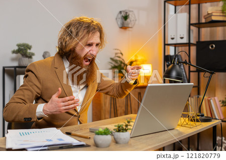 Upset businessman arguing on laptop call online displaying report charts graphs at home office table 121820779