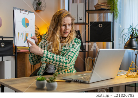 Upset businesswoman arguing on laptop call online displaying report charts and graphs at home office 121820782