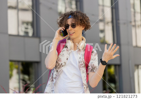Happy young man tourist having remote conversation communicate speaking by smartphone with friends Happy young man tourist having remote conversation communicate speaking by smartphone with friends 121821273