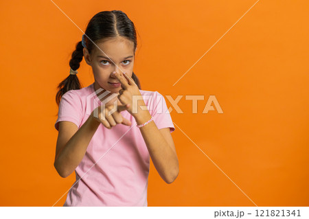 School child girl show pointing at her eyes and camera I am watching you gesture, spying on someone 121821341
