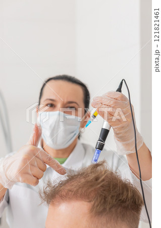 Trichologist doing man improve hair growth procedure, dermapen microneedling, vitamin injections Trichologist doing man improve hair growth procedure, dermapen microneedling, vitamin injections 121821461