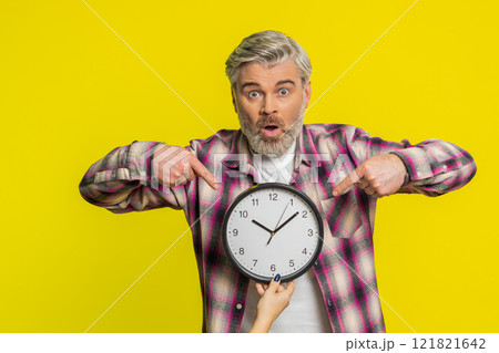 Mature man holding big office clock, urgent deadline sign, anxious lateness gesture time pressure 121821642