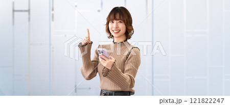 スマホを持って案内をする笑顔の女性・ビジネスウーマン スマホを持って案内をする笑顔の女性・ビジネスウーマン 121822247
