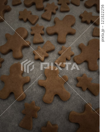 Gingerbread men and comets cookies baking on a tray and paper, ready for the holiday season christmas Gingerbread men and comets cookies baking on a tray and paper, ready for the holiday season christmas 121822256