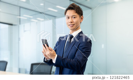 スマホを持つ笑顔の男性ビジネスマン 121822465