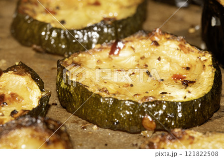 A roasted sliced seasoned aubergine eggplant courgette with salt and herbs cooked in the oven close up A roasted sliced seasoned aubergine eggplant courgette with salt and herbs cooked in the oven close up 121822508