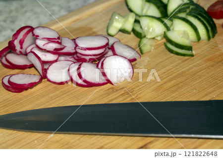 Chopped Up SlicedCuecumber and Radish on a Chopping Board in a Kitchen Chopped Up SlicedCuecumber and Radish on a Chopping Board in a Kitchen 121822648