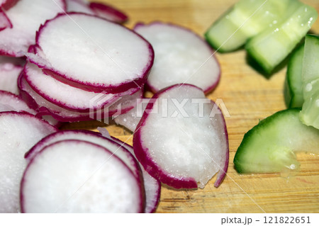 Chopped Up SlicedCuecumber and Radish on a Chopping Board in a Kitchen Chopped Up SlicedCuecumber and Radish on a Chopping Board in a Kitchen 121822651