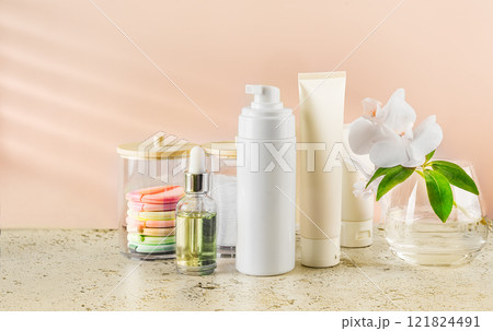 The set of facial skincare products and orchid on the stone table top in the bathroom 121824491