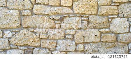 Sturdy yellow and beige cut stone wall, seamless lined up 121825733
