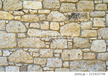 Sturdy yellow and beige cut stone wall, seamless lined up 121825736