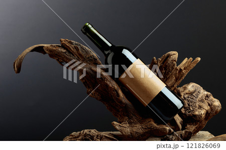 Bottle of red wine with empty label on a old snags. 121826069