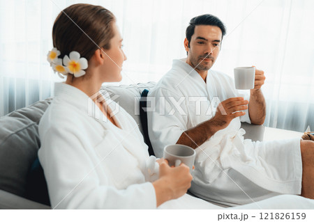 Couple wearing bathrobe relaxing with drinks in luxurious hotel spa. Quiescent Couple wearing bathrobe relaxing with drinks in luxurious hotel spa. Quiescent 121826159