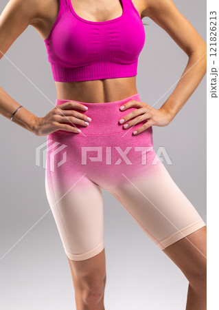Woman in Sporty Pink Outfit Displaying Fitness and Style, hands on hips, athletic shape concept Woman in Sporty Pink Outfit Displaying Fitness and Style, hands on hips, athletic shape concept 121826213